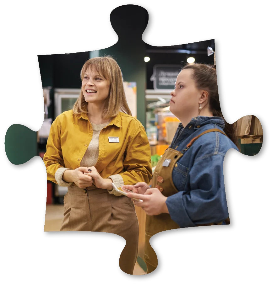 puzzle shape cutout featuring young adult woman employee and boss in discussion