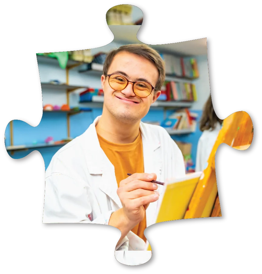 puzzle shape featuring smiling young man painting a picture